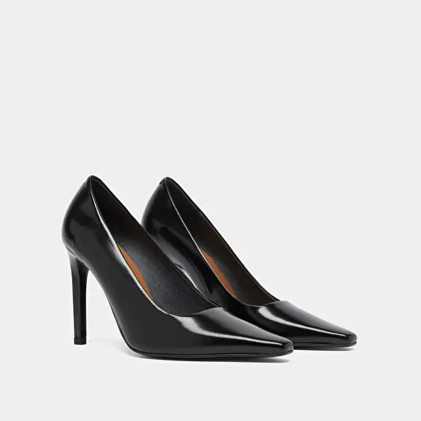 Pointed-toe pumps in black glazed leather